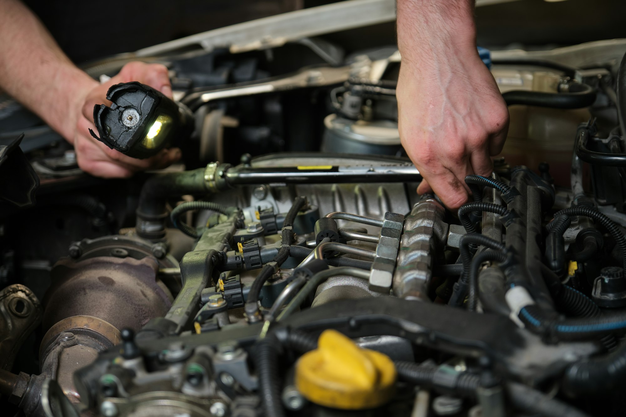 Close up of car mechanic hands doing car service and maintenance.